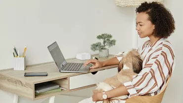 Woman utilizing flexible working options by working remotely from her organized home office, engaging with a laptop