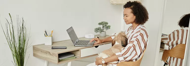 Woman utilizing flexible working options by working remotely from her organized home office, engaging with a laptop